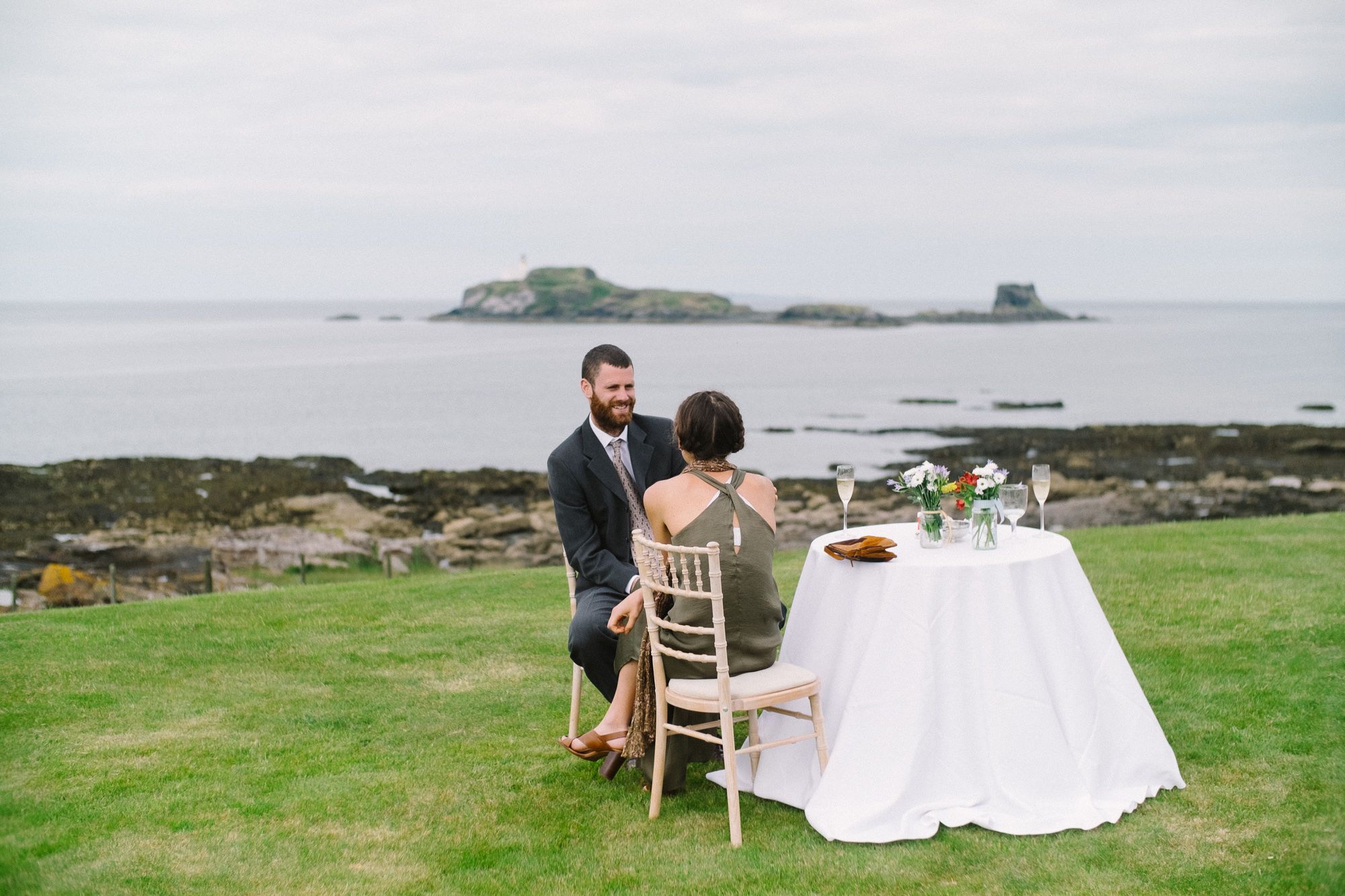 Wedding guests sitting at a table on the coast of Archerfield House Estate