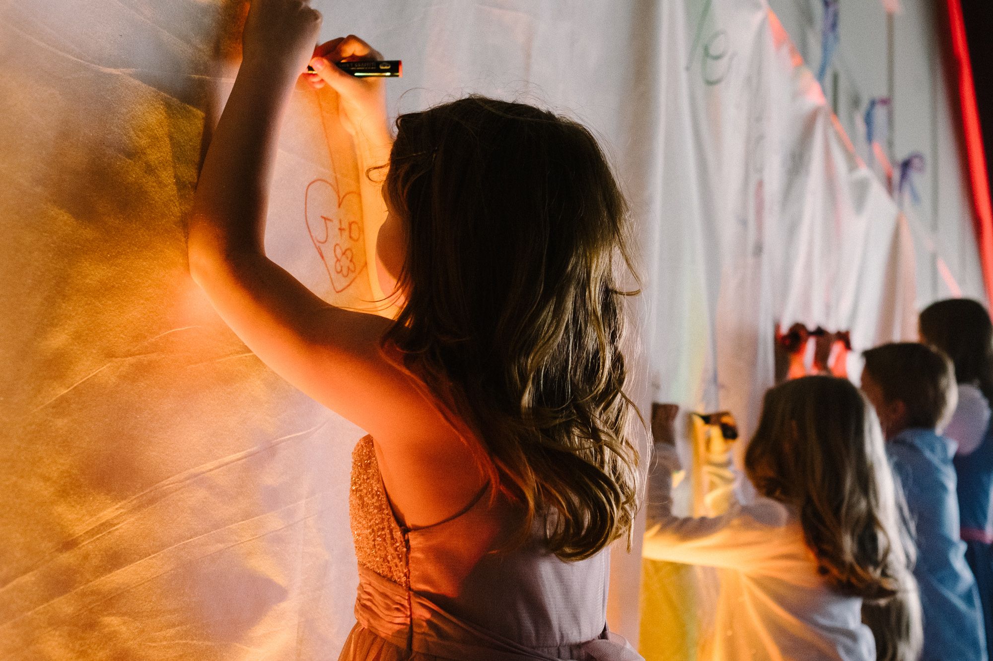 Child writing message for bride and groom before wedding dinner