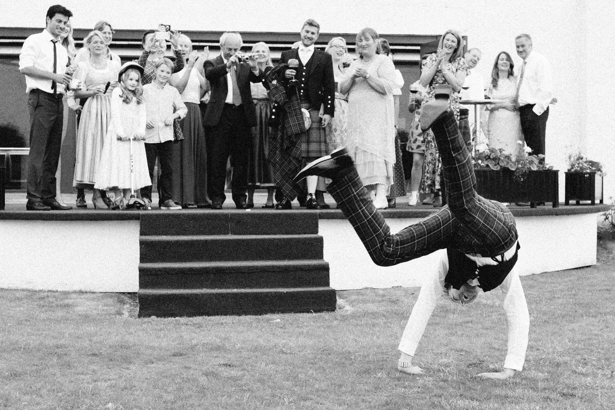 Wedding guest is doing a cartwheel to the enjoyment of spectators
