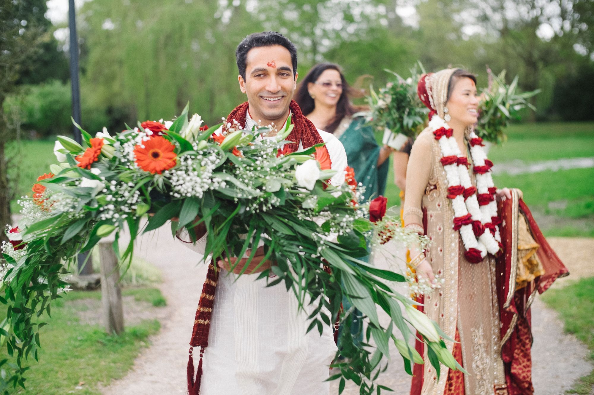 Joyful bride and groom with flowers after Hindu wedding ceremony
