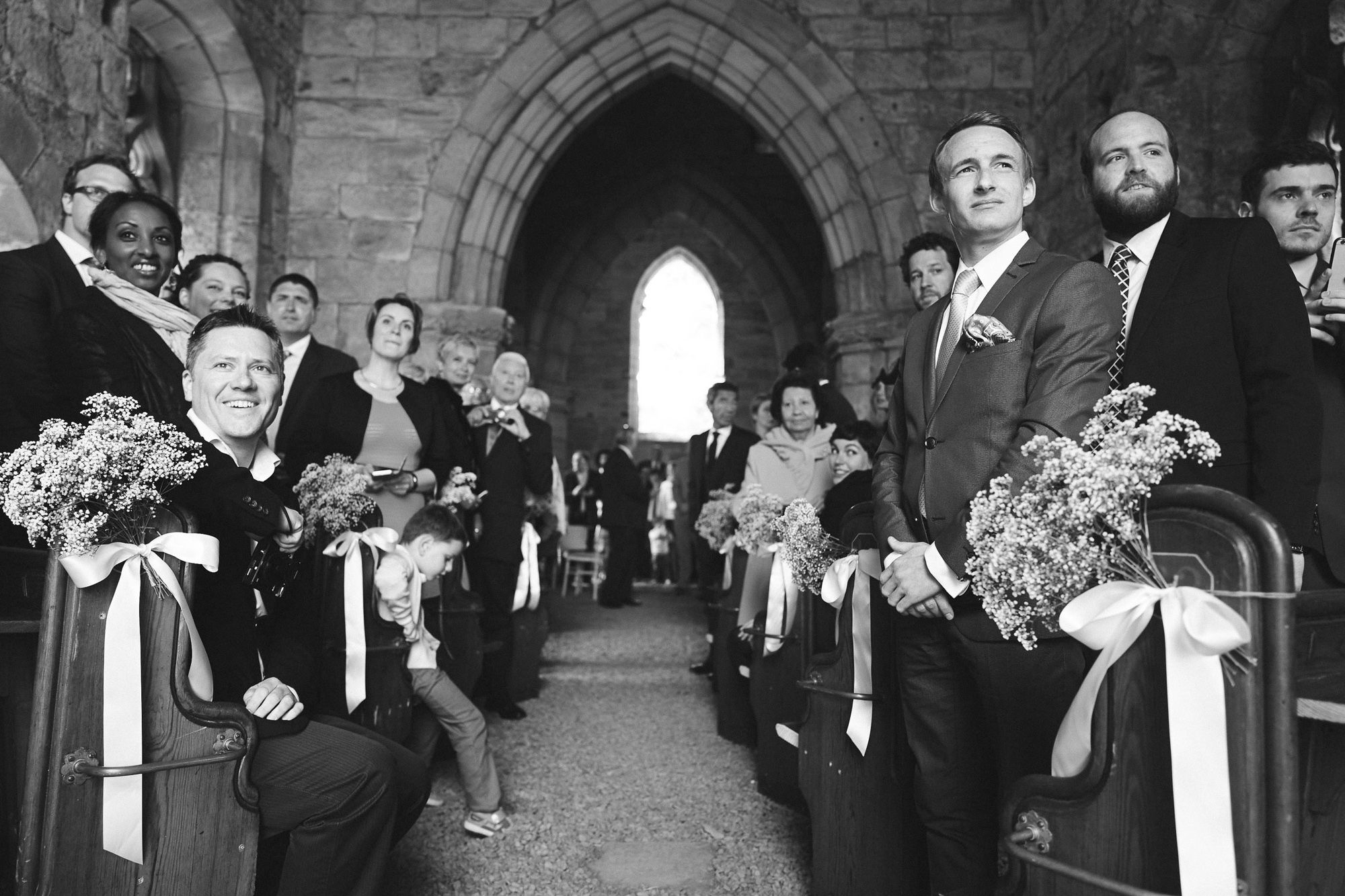 Wedding guests watch bride entering the church at Dunglass Estate wedding